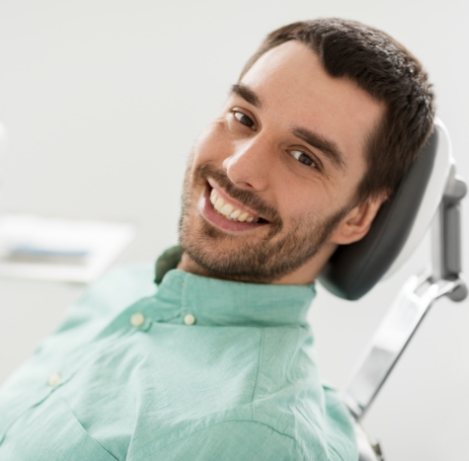 Smiling man leaning back in dental chair in Yukon dental office