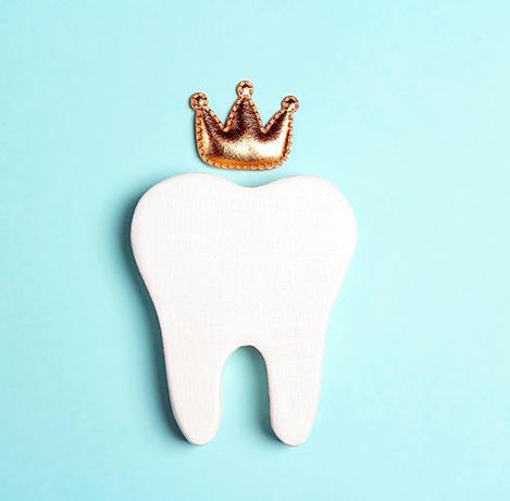 Wooden tooth and cloth crown on a blue background