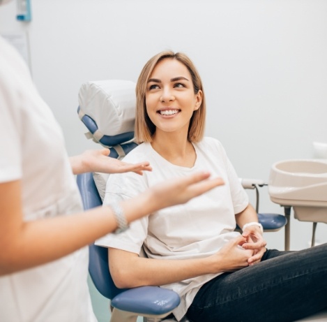 Woman in dental chair smiling at her dentist