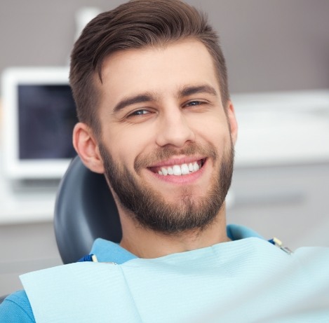 Young man with beard smiling during dental checkup